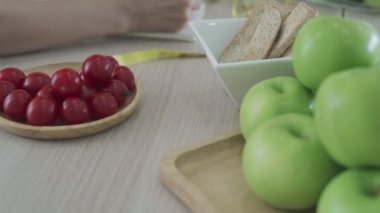 Hareket VDO. Defter kapağı yazan kadın diyet kontrolü ve kilo kaybı için kullanılır. Kadınlar ne kadar yediklerini belirlemek için her yemeğin yemek ve enerjisinin detaylarını yazdılar..