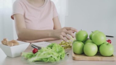 Diyet ve kilo kaybı kavramı. Kadınlar diyette yeşil elma yemeyi ve yağ ve abur cuburdan kaçınmayı tercih ederler. Kadınlar sağlıklı yiyecekleri mutlu olmak için seçerler..