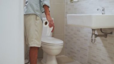 Karnı ağrıyan bir adam elini klozet kapağını açar. Erkekler sabah uyandıktan sonra ishal olurlar. İshal ve gastrit için sağlık kavramları.