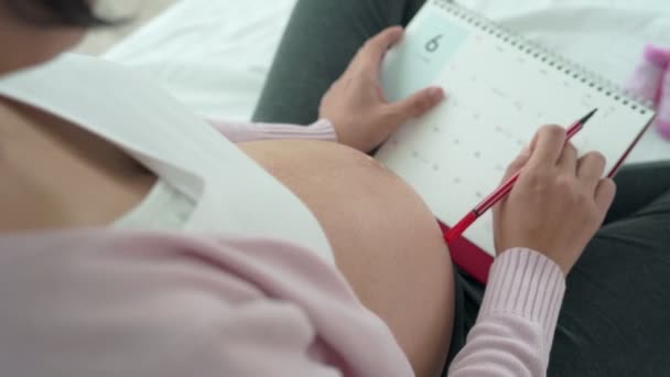 妊娠中の女性は出産の期日に印をつけている 帝王切開は妊娠中の女性が期日を知るための方法です 出産による概念 — ストック動画