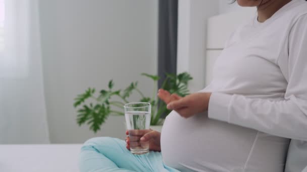 妊娠中の女性は生まれていない子供に栄養を与えるためにビタミンや飲料水を飲んでいます 妊娠中の女性の薬やビタミンを服用すると 胎児に影響を与えるように医師の管理下にある必要があります — ストック動画