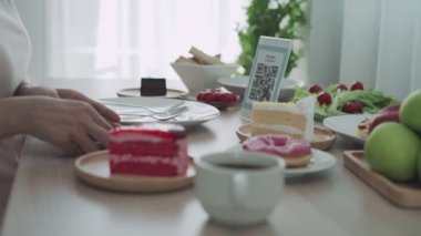QR ode çevrimiçi konseptini tara. Kadın yemek siparişini seçmek için QR kodunu taramak için telefonu kullanıyor. İndirim almak ya da yemek için ödeme yapmak ve parayı internet üzerinden aktarmak için kadın taraması. 