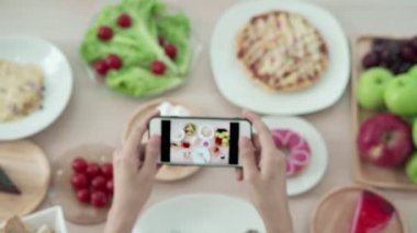 İnternet idolü ve eleştiri yemeği için fotoğraf çek. Kadınlar yemek fotoğrafları çekmek ya da sosyal ağ uygulamalarında canlı video çekmek için cep telefonu kullanıyor. Öğle yemeği iştah açıcı görünüyor.. 