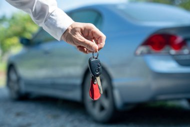 Araba satışı, araba satışı, anlaşma konsepti. Satıcı arabanın anahtarlarını sigorta sözleşmesi olan yeni sahibine ya da kiracıya verir..