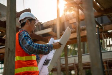 Müteahhit yeni evin taslak çizimini gözden geçirdi. Mühendisler inşaat detaylarını gerçek alandaki çizim karşılaştırmalarında okuyorlar. İnşaat mühendisi ve müfettiş kavramı