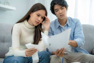 Asyalı çiftler borçlar ve harcamalar konusunda endişeliler. Stresli kadınlar ve erkekler banka kredi makbuzları alıyorlar. Kredi kartı, su, elektrik, telefon faturaları. Parasız ve meteliksiz