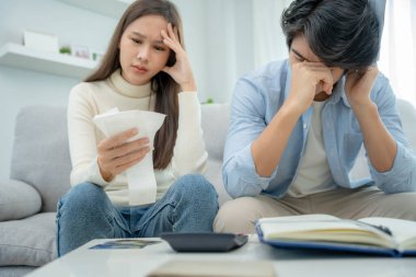 Asyalı çiftler borçlar ve harcamalar konusunda endişeliler. Stresli kadınlar ve erkekler banka kredi makbuzları alıyorlar. Kredi kartı, su, elektrik, telefon faturaları. Parasız ve meteliksiz