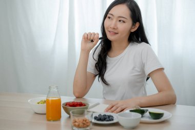 Diyet, diyet. Keto 'lu kadınlar kilo vermeyi planlıyorlar, zayıf ve sağlıklı. Kadın doğru beslenme, sebze, badem, avokado, domates ve salata ile eğleniyor. Sağlıklı beslenme uzmanı