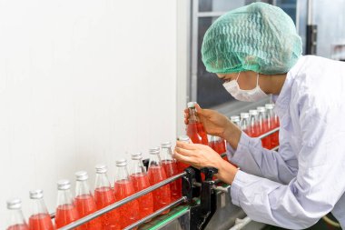 Kalite kontrol mühendisleri meyve suyu veya ilaç üretim ve şişeleme tesisinde çalışıyorlar. Personel, müşterilere teslim edilmeden önce gıda ve uyuşturucu kalitesini denetlemektedir
