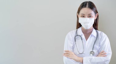 Üniformalı ve tıbbi maskeli kadın doktor ya da hemşire. Hastane ya da klinik personeli korona virüsünü önlemek için maske takıyor. Portre kadın konsepti