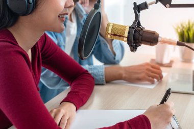 Stüdyoda Radyo Host Podcast. Erkek ve kadın hoparlörler bilgisayarlarındaki mikrofon ve kameralar aracılığıyla konuşurlar. Sabah yaşa.