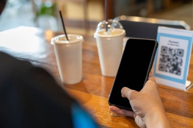 Erkekler, menü seçmek ya da indirim almak için taramak ya da bir kafede yiyecek ve içecek için ödeme yapmak için bir QR kodunu taramak için telefon kullanırlar. Parayı transfer etmek için ya da nakit olmadan internet üzerinden ödeme yapmak için..