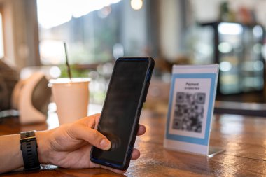 Erkekler, menü seçmek ya da indirim almak için taramak ya da bir kafede yiyecek ve içecek için ödeme yapmak için bir QR kodunu taramak için telefon kullanırlar. Parayı transfer etmek için ya da nakit olmadan internet üzerinden ödeme yapmak için..