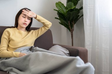 Üzgün kadın migren ağrısı, depresyon ya da hasta hissediyor. Hayal kırıklığına uğramış Asyalı kadın alnına dokunuyor ve ateşi var..