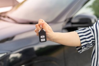 Bir turist araba kiralama şirketinin çalışanı arabanın anahtarlarını test sürüşü ile sunar. Kira kontratını kabul etmeden önce iyi hizmet.