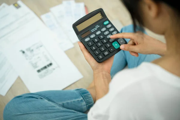 Debt. Women calculate expenses with large bills. Stressed housewife looking for a way to pay credit card bills.