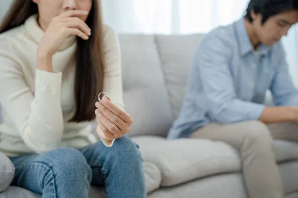 Divorce. Woman taking off wedding ring. Asian couples are desperate and disappointed after marriage. Husband and wife are sad, upset after quarrels. distrust, love problems, betrayals. family problem