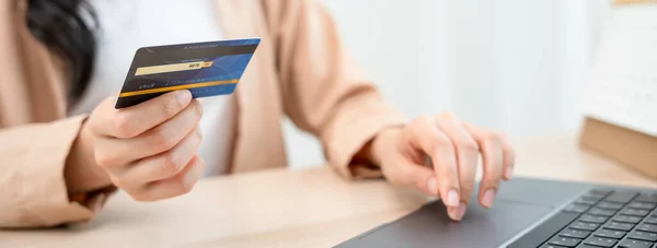 woman uses a credit card to pay for goods after shopping online through a socially marketed merchant\'s website. The buyer pays for water, electricity and telephone bills via computer by debit card.