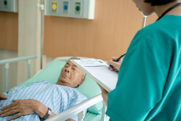 亚洲女医生用节拍器检查一位患有心脏病的老年男子的心脏肺 专业医生为住院病人提供心理治疗方面的建议和谈话 — 图库照片