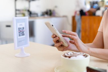 Turistler yemek siparişi vermek, menü seçmek, yemek ve hizmet için ödeme yapmak için QR kodlarını taramak için telefon kullanırlar. Seyahat et ve yeni normaller için para harca