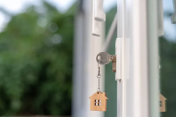 The house key is inserted in the door. Selling and renting a house concept
