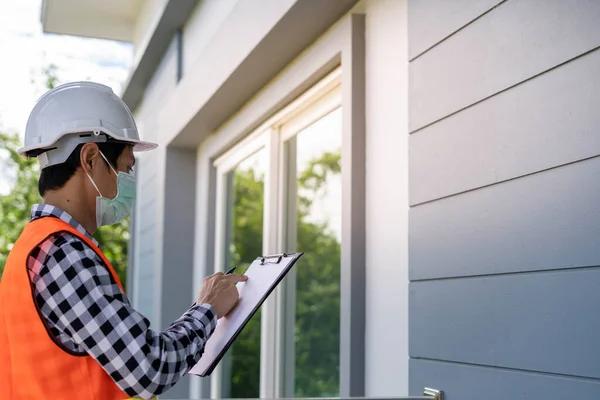 An inspector or engineer is inspecting and inspecting a building or house using a checklist. Engineers and architects work to build the house before handing it over to the homeowner.