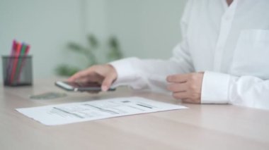 İş kadını, internet üzerinden belge faturasını aldıktan sonra kredi kartı faturalarını ödemek için barkod veya QR kodlarını taramak için telefon kullanıyor. Ödeme, ödeme, ödeme elektrik, dijital ödemeler para, teknoloji, tarama olmadan