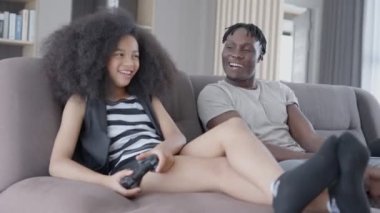 Baba ve kızı tatil günü konsol oyunu oynayarak eğleniyorlar. Kızı kazandıktan sonra çok mutlu. Tatil aile aktiviteleri konsepti.