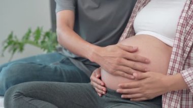 Bebeğin hareketlerini kontrol etmek için karnına dokunan koca. Koca, doğmamış kızının hareketine dikkatle dokunur..