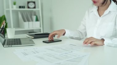 İş kadını, internet üzerinden belge faturasını aldıktan sonra kredi kartı faturalarını ödemek için barkod veya QR kodlarını taramak için telefon kullanıyor. Ödeme, ödeme, ödeme elektrik, dijital ödemeler para, teknoloji, tarama olmadan