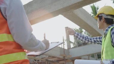 Ustabaşı yapısal detayları mühendise gösteriyor. Denetim mühendisi çeşitli bölgelerdeki güçlendirilmiş beton yapının ayrıntılarını kaydediyor. Konsept müfettişi..