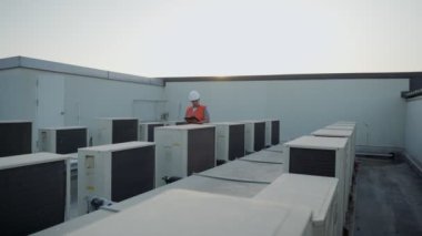 Müfettişler akşam fabrikanın soğutma sistemini kontrol ediyorlar. Adam bakım planından önce kompresörün durumunu kaydediyor. Bakım bölümü kavramı.