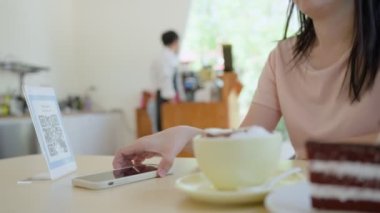 Kadınlar kahve parasını ödemek için cep telefonu taramasını QR koduna göre kullanırlar. Konforlu ödeme için mobil tarama çevrimiçi. Yeni normal ve çevrimiçi maaş kavramını kabul et.