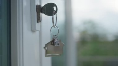 Yeni ev ve arazi lordu. Yeni bir evin kilidini açmak için anahtar. Rüzgar eserken anahtarlık hareket ediyordu. Ev sahibi ve yeni ev sahibi kavramı
