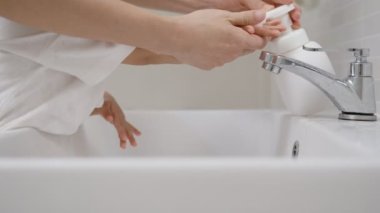 Anne kahvaltıdan önce ellerini yıkama alıştırması yapıyor. Virüsü korumak ve azaltmak için ellerini yıkamak. Mikropları ve virüsü önlemek için konsept..