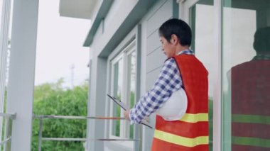 QC Mühendisleri evi teftiş ediyor ve evin uyumsuzluğunu tekrar kontrol ediyor. Teftiş mühendisleri, ev teftişlerinde müşterileri rahatlatmak için maske takarlar. yeni ev teftişi kavramı.