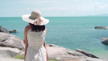 Eğlence konsepti. Kadınlar tek başlarına duruyorlar ve deniz kenarında gün ışığına çıkıyorlar. Kadınlar plaj atmosferinin tadını çıkarırken rüzgarda sallanan elbiseler ve peçeler takıyorlardı. Denizde yalnız seyahat eden bir kadın..