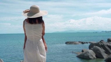 Çamaşır suyu kavramının yeniden canlandırılması. Kadınlar plaj atmosferinin tadını çıkarırken rüzgarda sallanan elbiseler ve peçeler takıyorlardı. Tatilde tek başına denizde seyahat eden bir kadın..