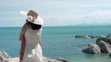 Çamaşır suyu kavramının yeniden canlandırılması. Kadınlar plaj atmosferinin tadını çıkarırken rüzgarda sallanan elbiseler ve peçeler takıyorlardı. Tatilde tek başına denizde seyahat eden bir kadın..