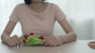 Kadınlar sağlıklı olmak için doğru yiyeceği seçiyorlar. Kadınlar oruç tutuyor. Diyet yemek ve abur cubur arasında karşılaştırma seçenekleri. ağırlık ölçümü, dijital ölçekler, kilo kaybı.