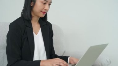 İş kadınları mal üretimini planlamak için bilgisayarlarla çalışırlar. İş adamları belgelere ve bilgilere bakar. Asyalı kadın çalışırken gülümser.