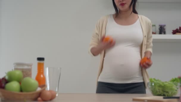 孕妇在准备橙汁的时候手上拿着橙子 孕妇的良好情绪有助于胎儿的大脑发育 感情的概念影响发展 — 图库视频影像