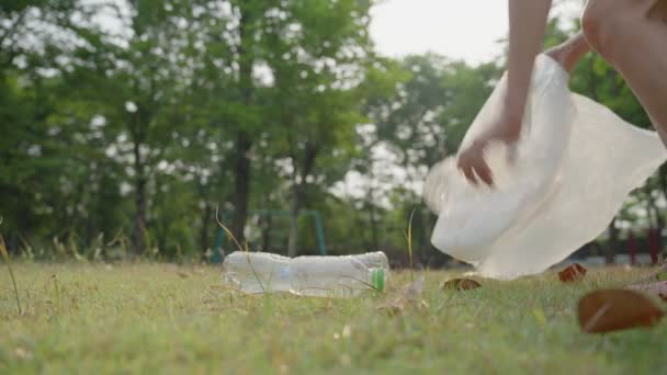 公園によって廃棄された汚染を拾うための女性ボランティア 女性は世界を防ぐために分解しにくいペットボトルを保管しています — ストック動画