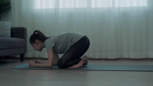 美丽的亚洲女人在家里玩瑜伽放松一下 一个女人减少她的肚子 锻炼她的肌肉 按瑜伽概念划分的健康和娱乐 — 图库视频影像
