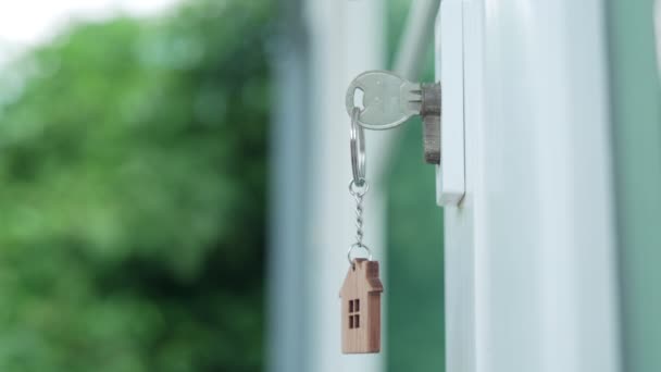 房东为新房子 打开新房锁的钥匙插在门上了 钥匙链在风中飘扬 — 图库视频影像