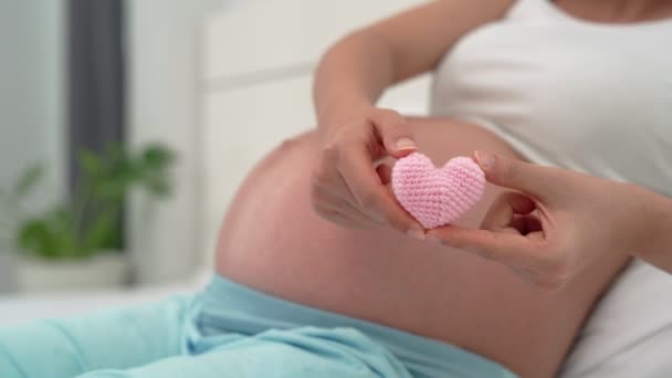 妊婦は胎児への愛のためのミニハートピンクを示しています ピンクのハートは 子供の重要性のための女性の気持ちを表しています 母子関係の概念 — ストック動画