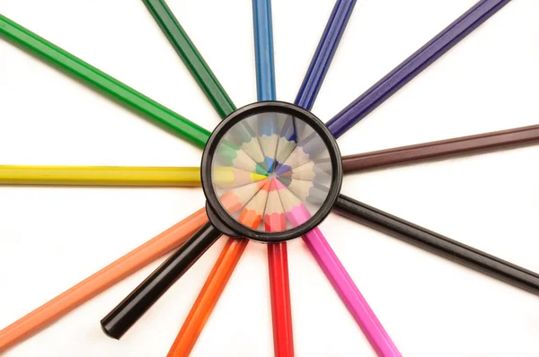 Magnifier and colored pencils — Stock Photo, Image