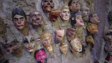 Weird Traditional Latin American Masks grouped in Cave Rock Wall, Traditional Masks from Guatemalan Culture hung against a Cave Rock Wall. High quality 4k footage