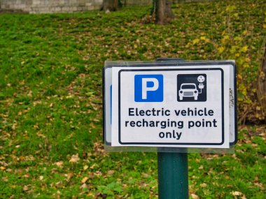 Bir otoparktaki dikdörtgen tabela sadece elektrikli araç için ayrılmış bir otoparkı gösteriyor..