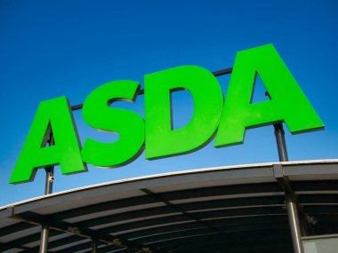 ASDA İngiliz süpermarket zincirinde kurumsal tabela. Güneşli bir günde bulutsuz, mavi bir gökyüzüne karşı çekilen.